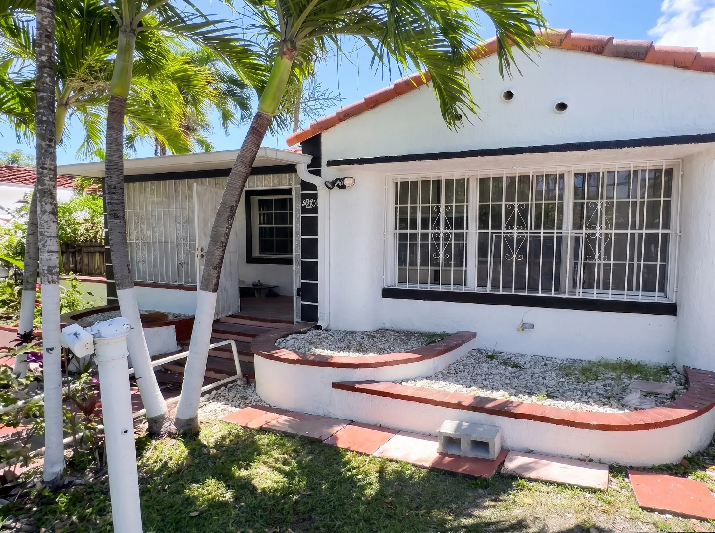 House exterior with metal window grilles and curved front steps