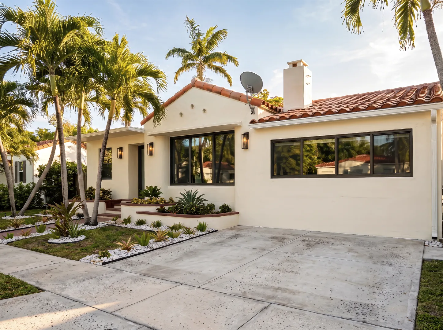House exterior with landscaping, a driveway and dark-framed windows