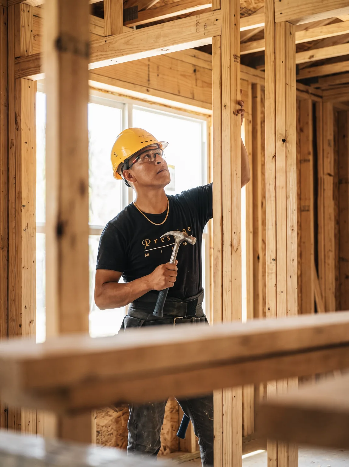 Person holding a hard hat and looking at exposed framing