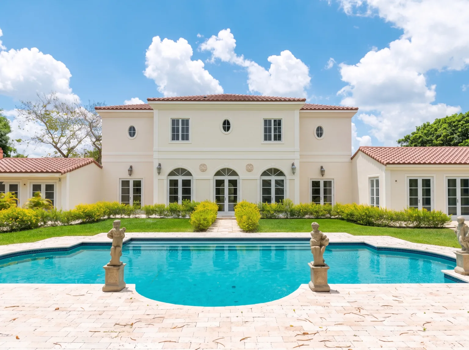 House exterior with a pool, a central entrance and planted grounds